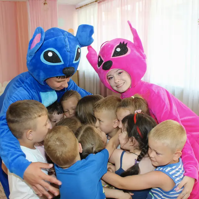 Аніматори Стіч та Енджел обіймають групу малюків